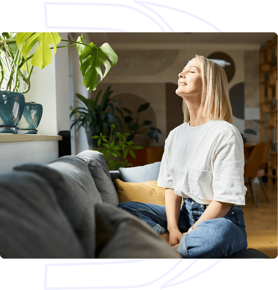 Woman smiling in sunlit living room.